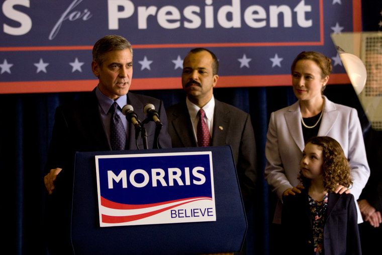 Governor Morris (George Clooney, left) addresses supporters after receiving Senator Thompson's (Jeffrey Wright, center) endorsement; Morris' wife, Cindy (Jennifer Ehle, right) and their daughter (Talia Akiva, bottom right) stand by in Columbia Pictures' IDES OF MARCH.
